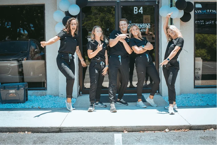 Five healthcare workers pose playfully outside Innerworks clinic